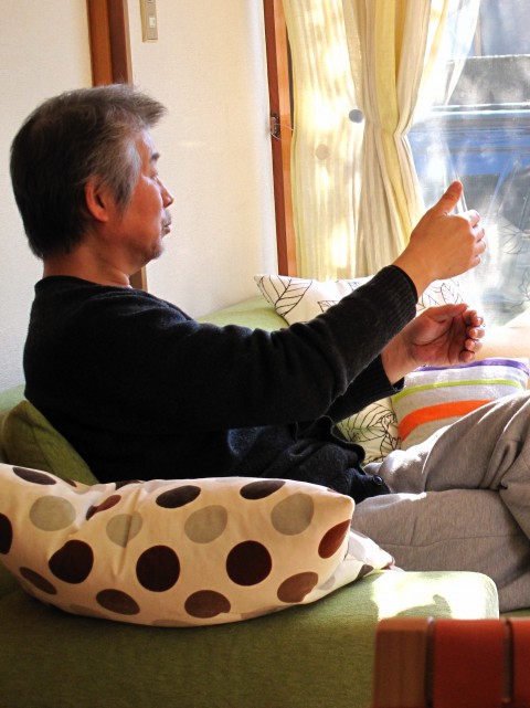 2012/12　新しいアイディアを友人に語っている久山　/　大好きな自宅リビングにて